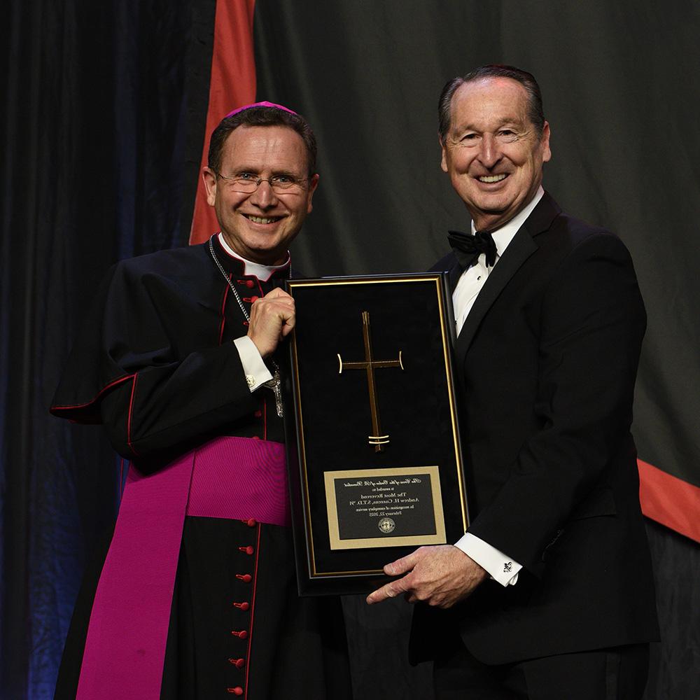 President Minnis holds the Cross of the Order of St. Benedict Award with the awardee, The Most Rev. Andrew Cozzens, STD ’91, Bishop of the Diocese of Crookston, Minnesota